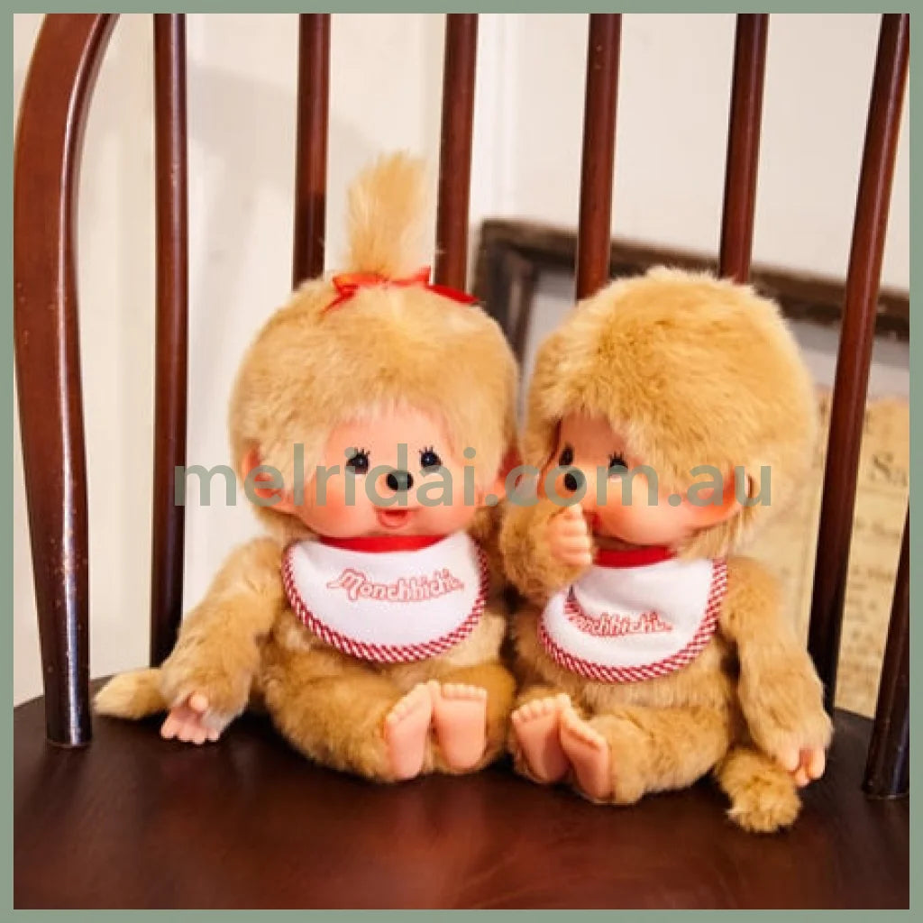 Two plush toys sitting on a wooden chair with a neutral background. Monchhichi